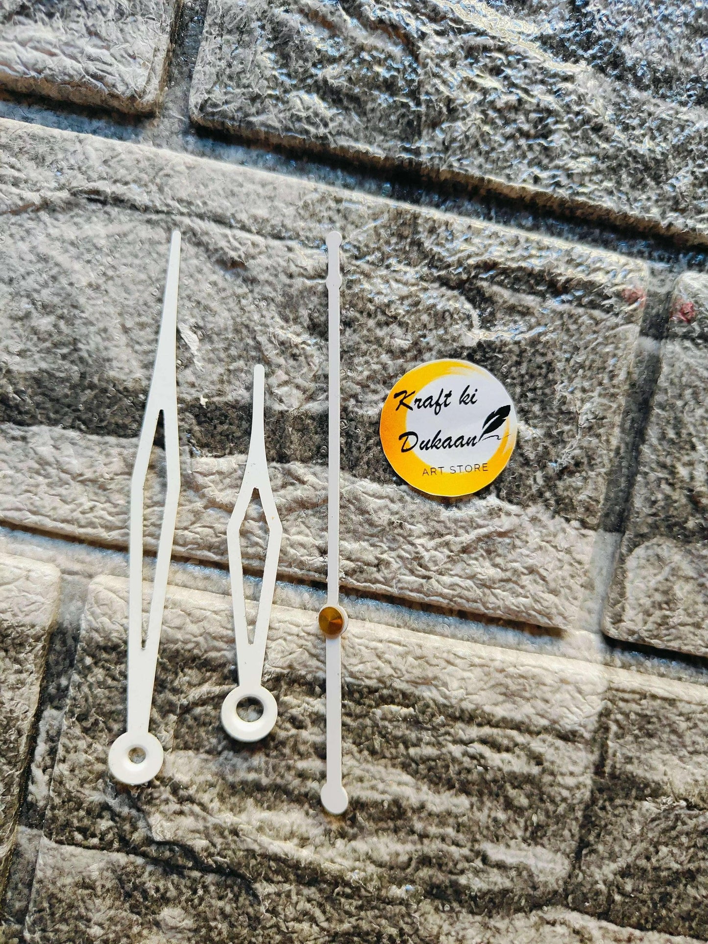 White and silver metal clock hands set with one gold-colored hand