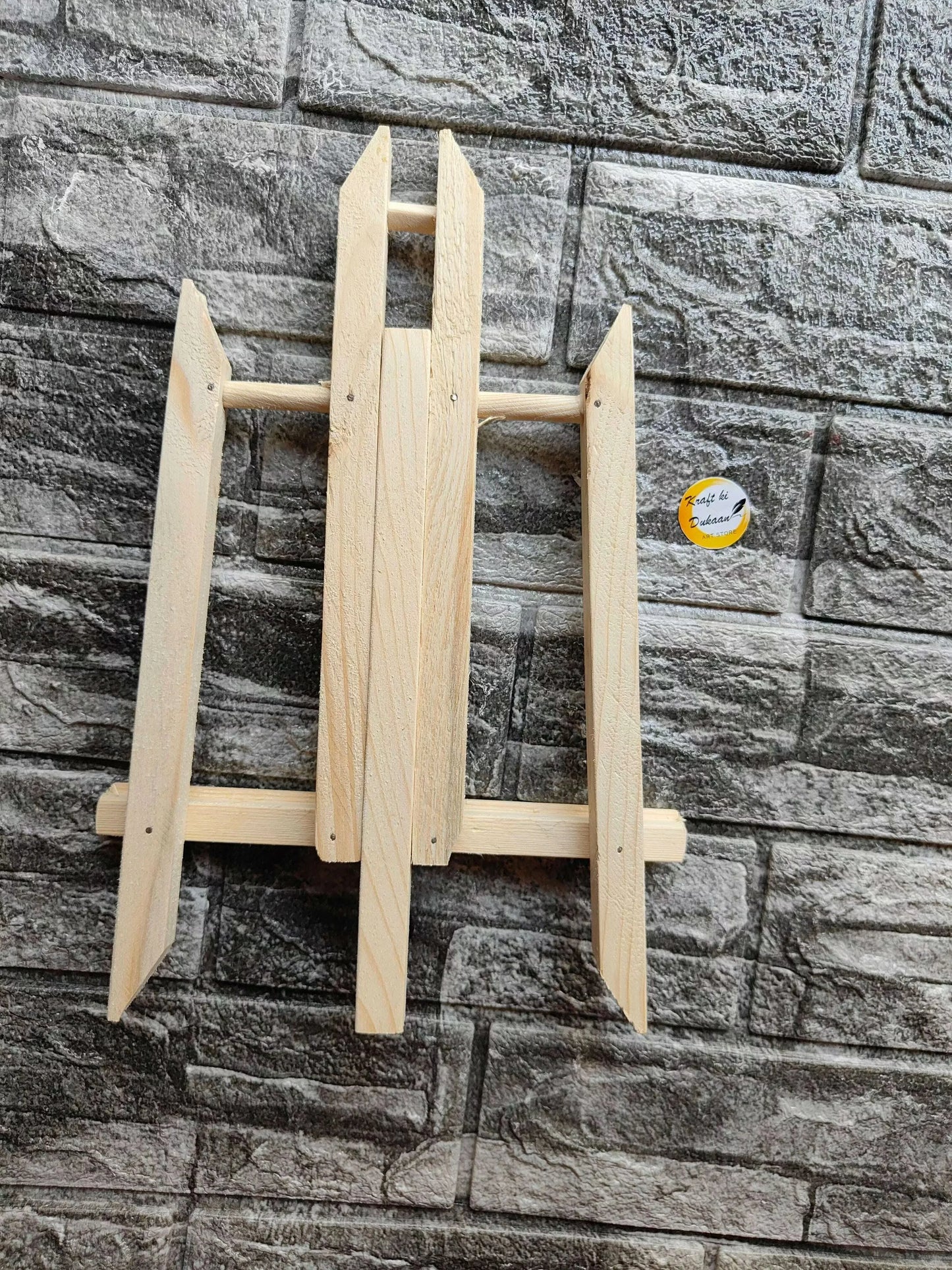 Wooden easel stand with pointed legs and open back frame with base rail