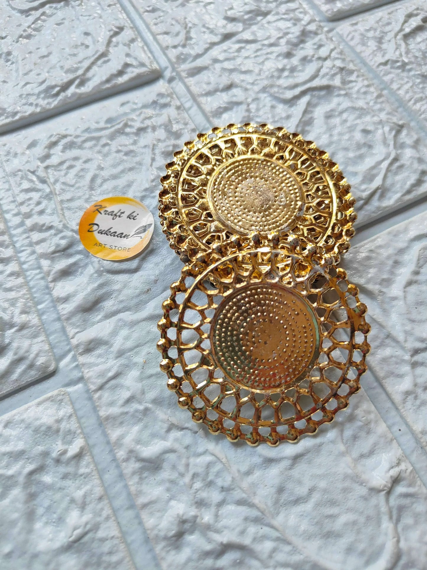 Two golden round t-light metal plates stacked, ornate lace border with dotted centers