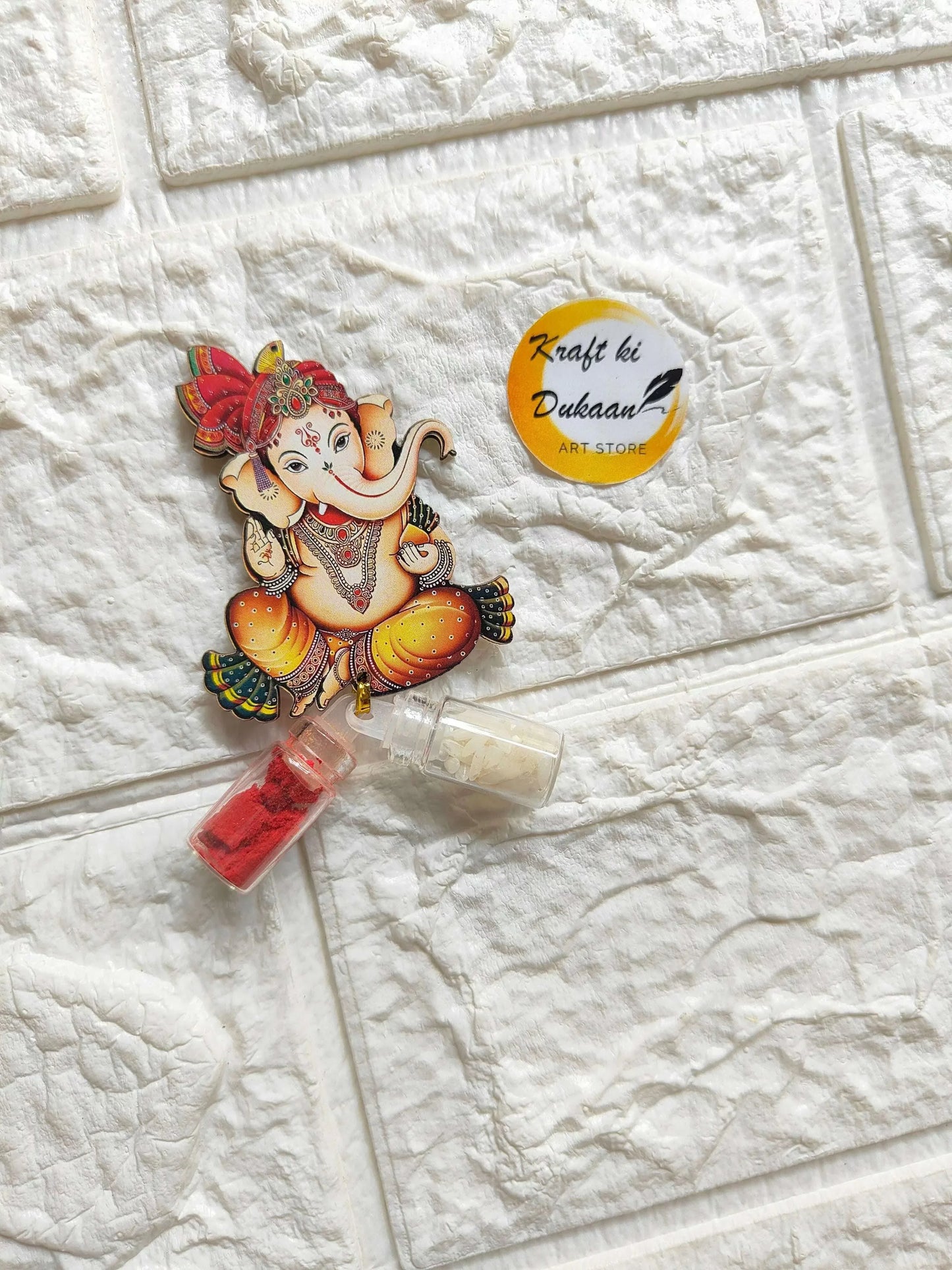 Roli-chawal bottle set featuring painted Ganesha topper with two clear powder bottles