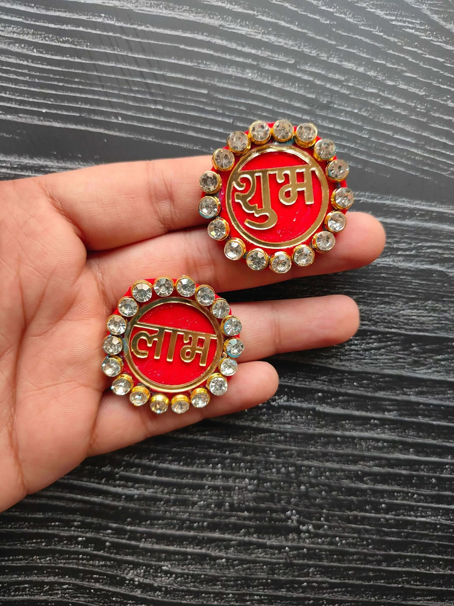 Shubh and Labh acrylic pearl round badges in hand, red centers with rhinestone rim