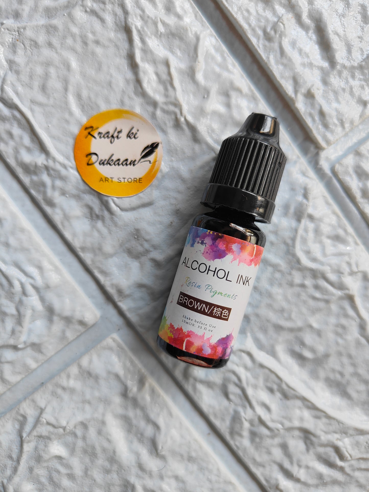 Brown alcohol ink for resin art in a small bottle by Kraft ki Dukaan with vibrant floral label