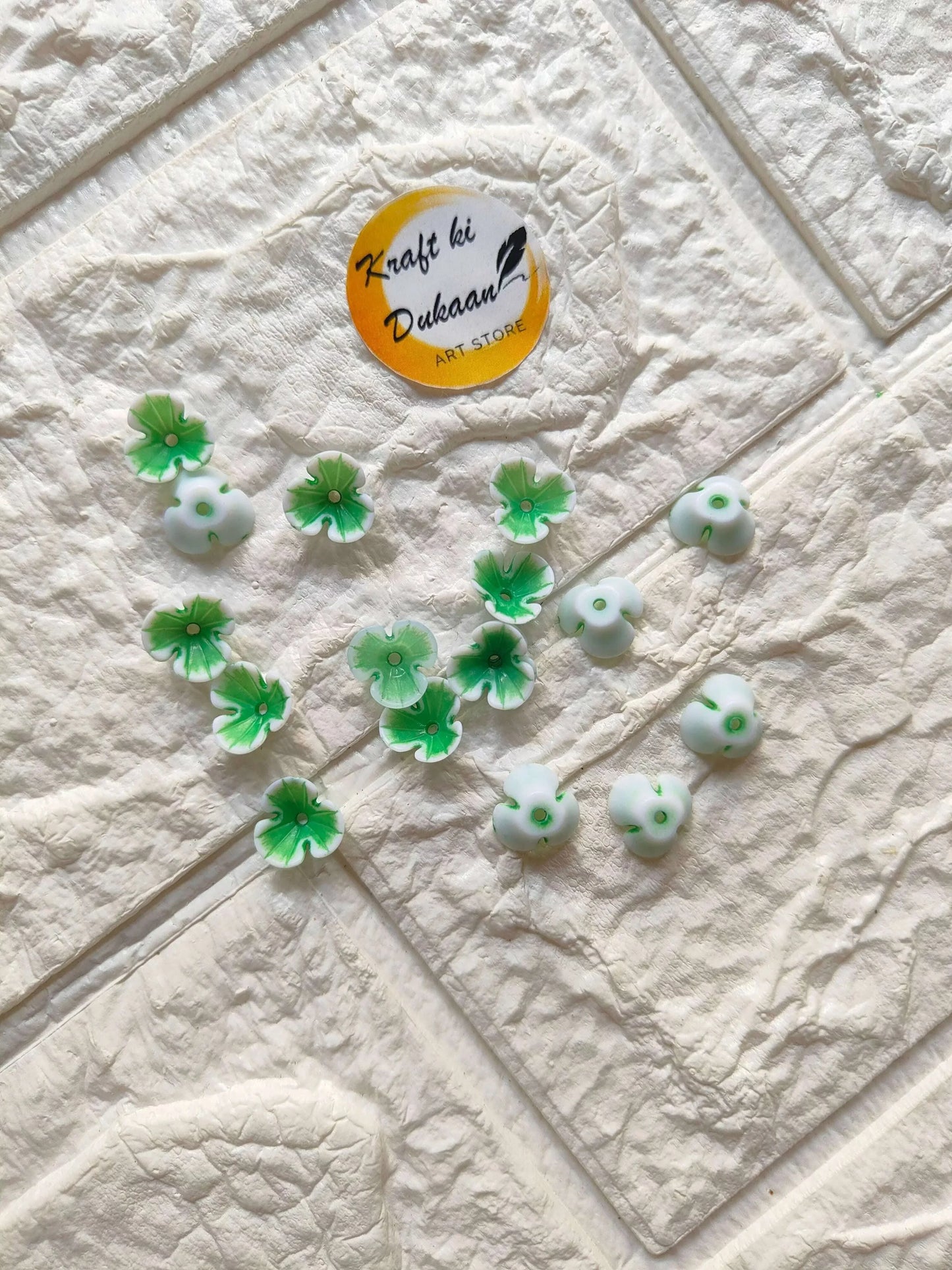 Green flower beads with white centers, small five-petal charms