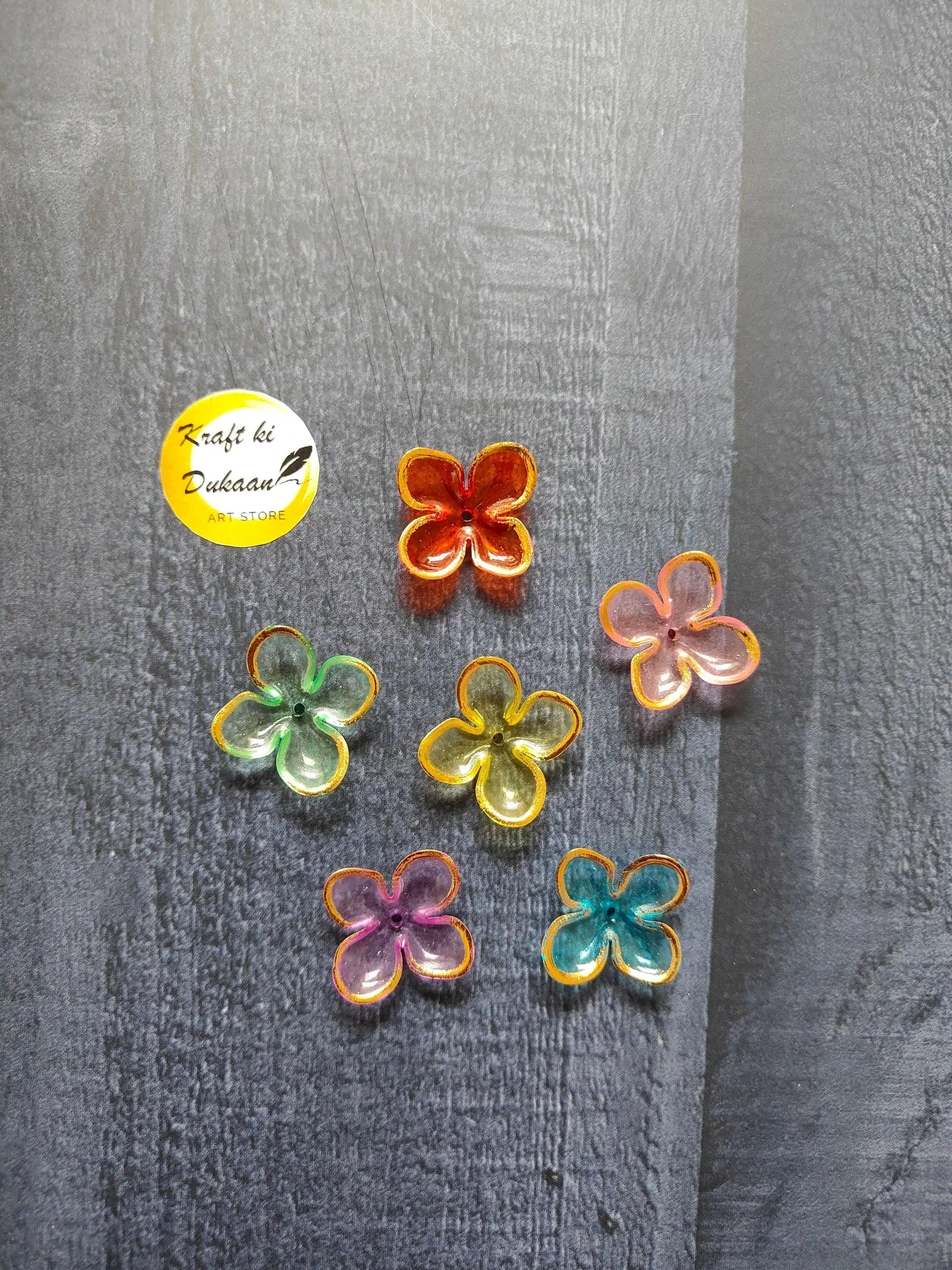 Flower-shaped bead charms in red, green, orange, and pink with yellow borders