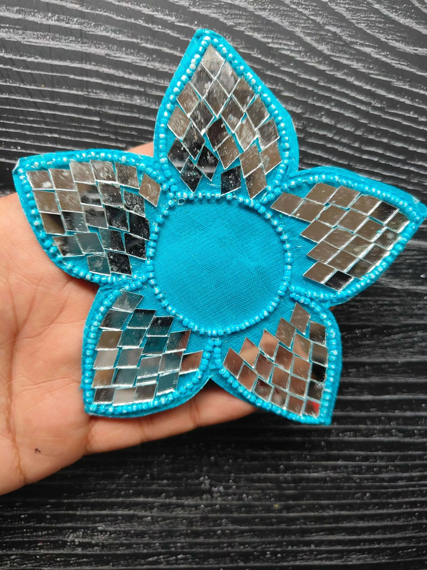 Sky-blue mosaic flower patch with stitched edge and round center