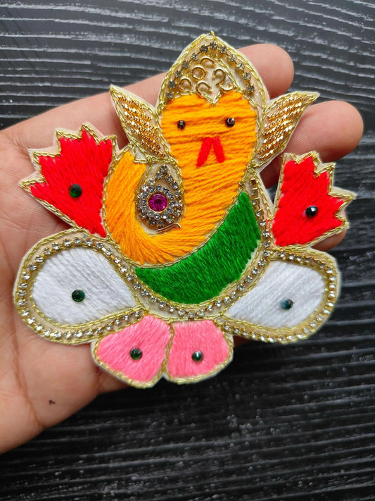 Bird applique patch close-up with embroidered details, red petals, white eyes and pink feet
