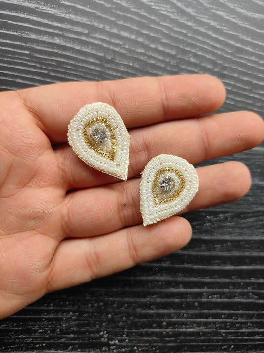 Tear-drop sequin patches on hand: white beadwork with gold center rhinestone