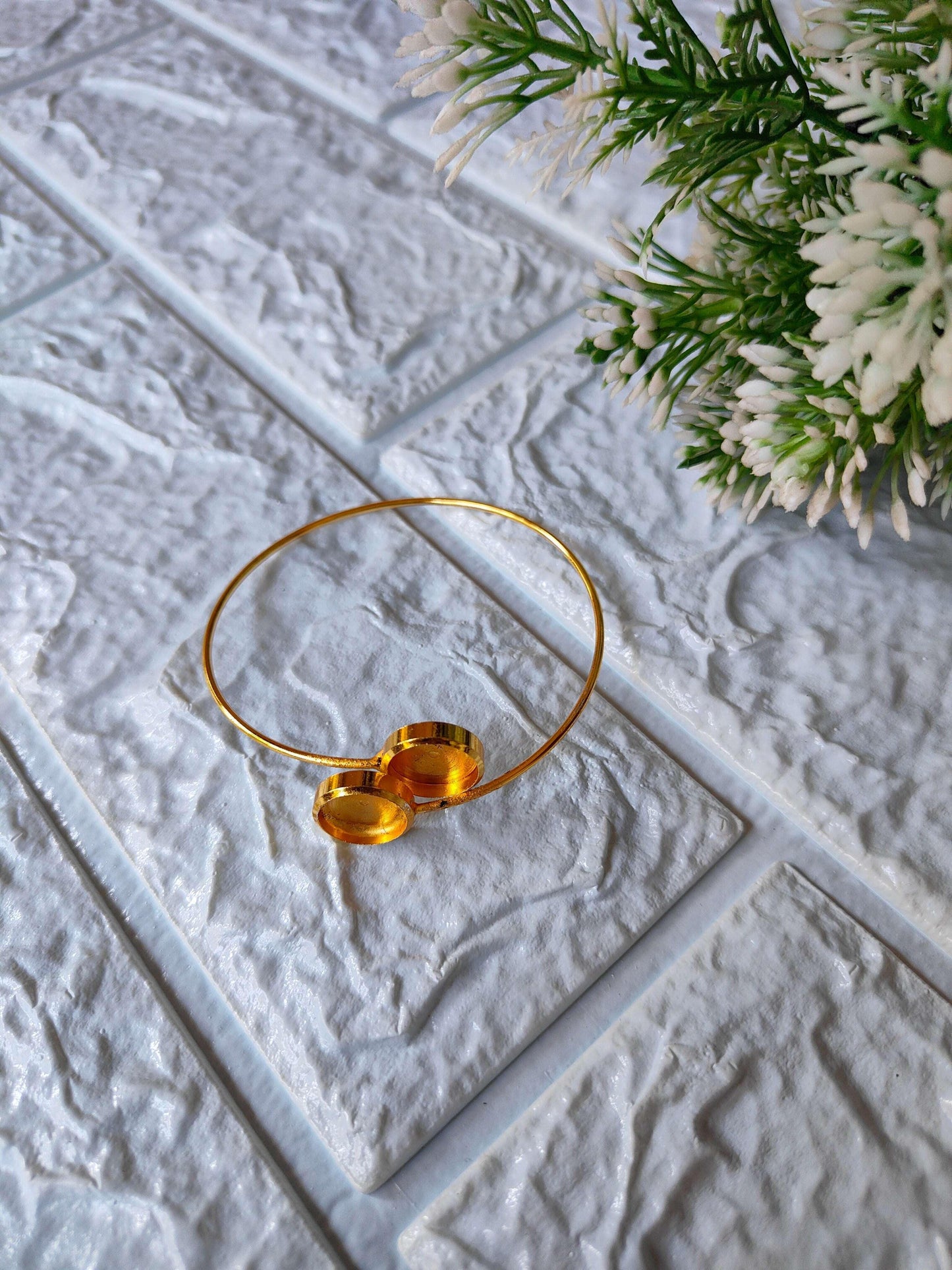 Gold bracelet with two round mirror-like discs on a thin open bangle