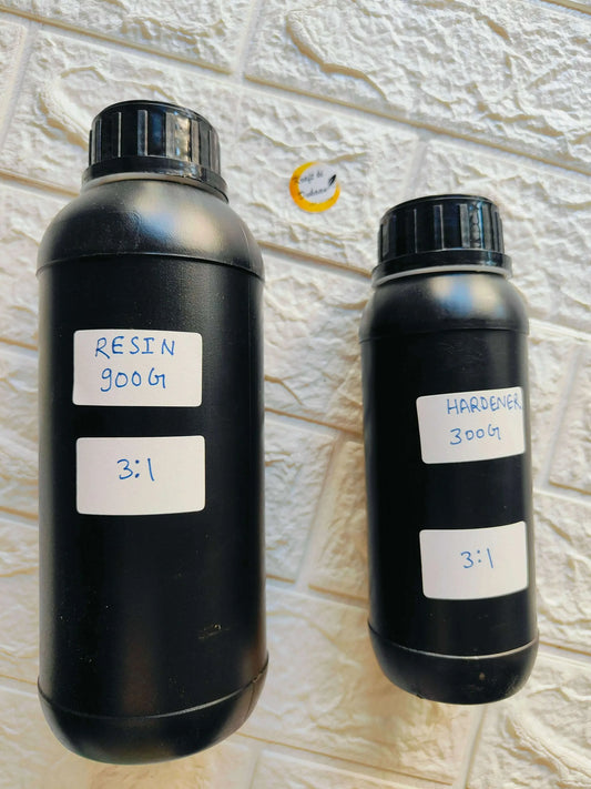 Two dark epoxy resin and hardener bottles with handwritten 3:1 ratio labels