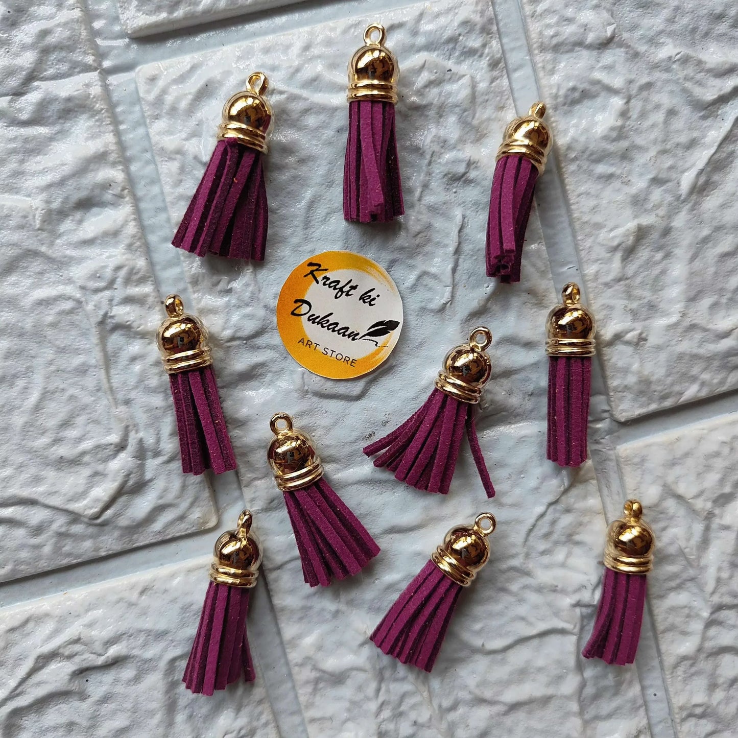 Gold leather tassel charm with wine/magenta tassels and gold-tone end caps