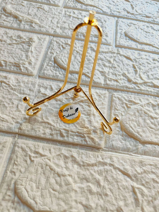 Foldable golden metal hanger stand with arched top and two lower cradle hooks
