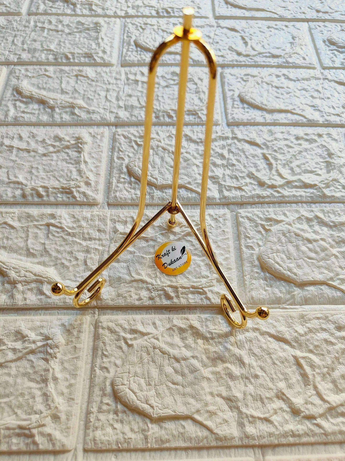 Foldable golden metal hanger stand with tall frame and two U-shaped support hooks