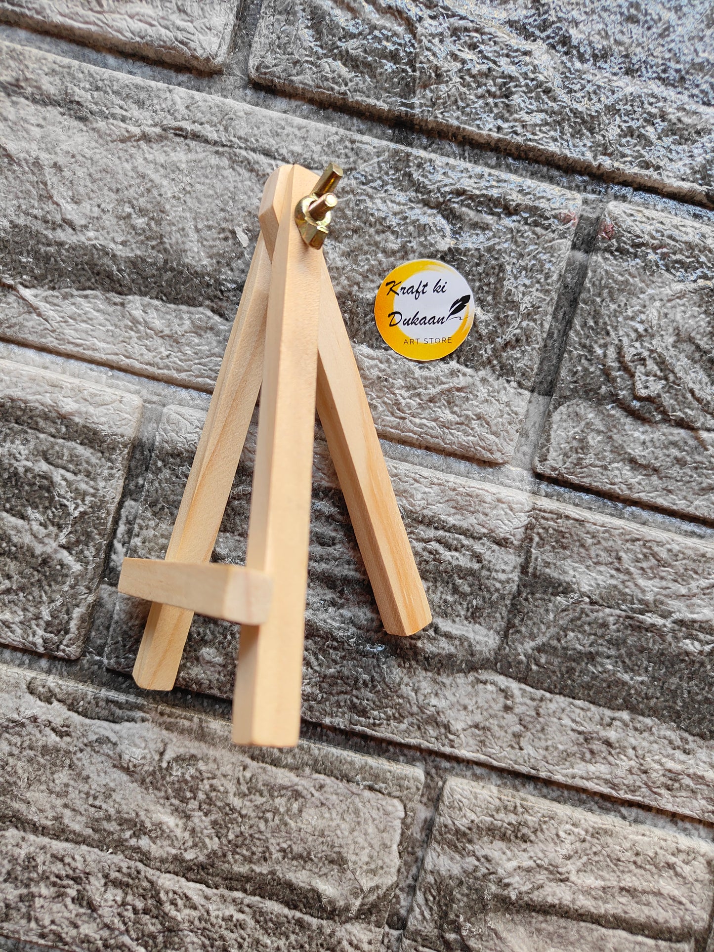 Kraft ki Dukaan 5 inch wooden easel for crafts displayed against a textured brick wall background