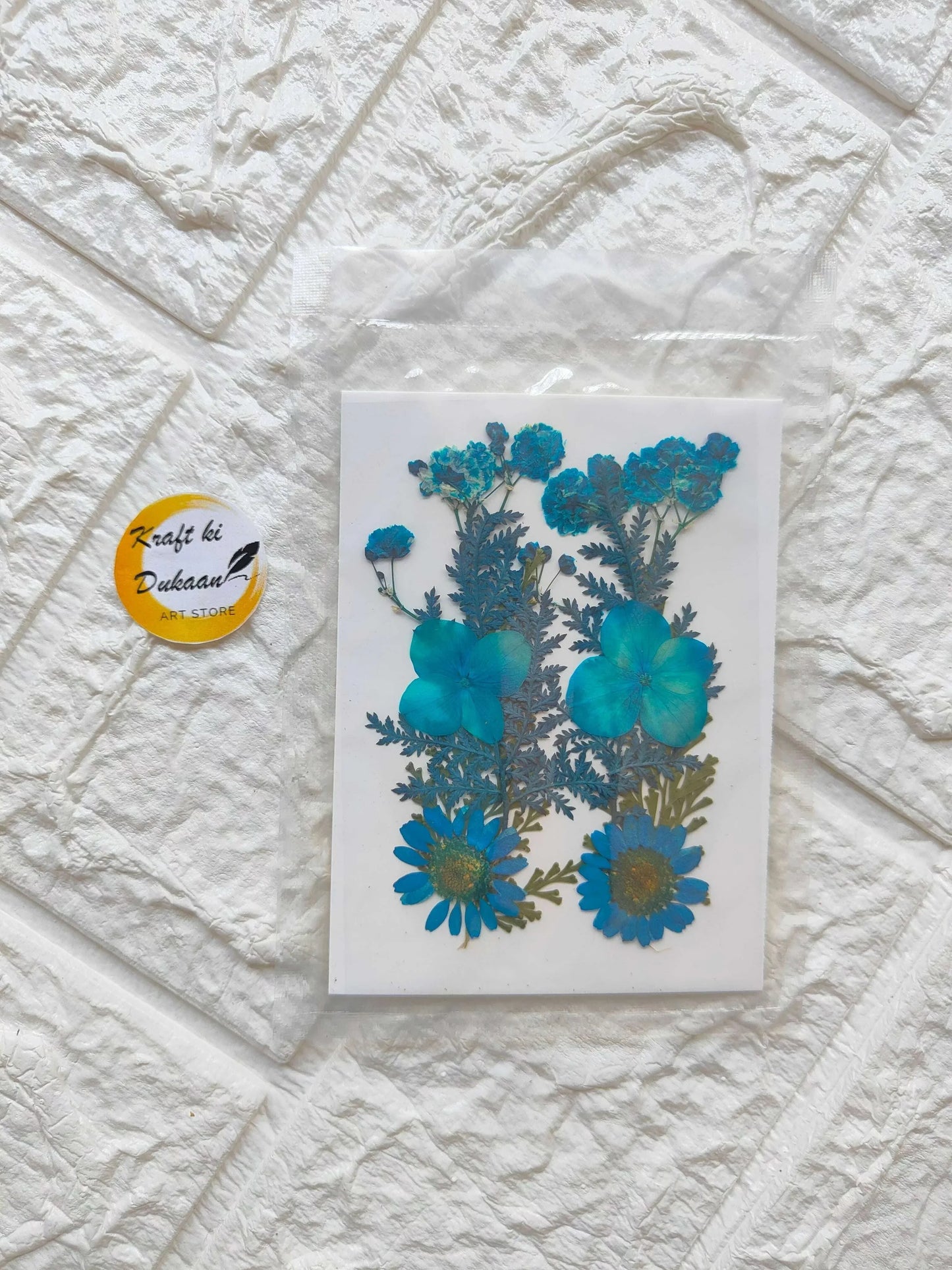 Pressed Flower Sheet Blue Mix with blue blossoms and leaves on white sheet
