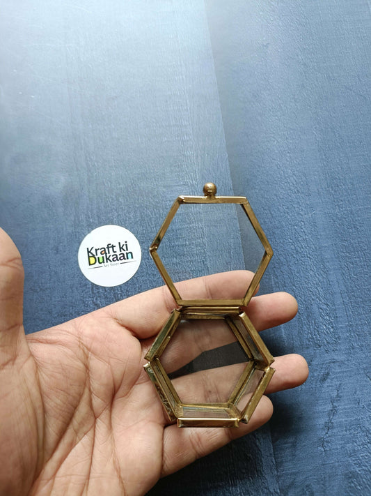 Brass hexagon glass box in hand, open with hinged lid