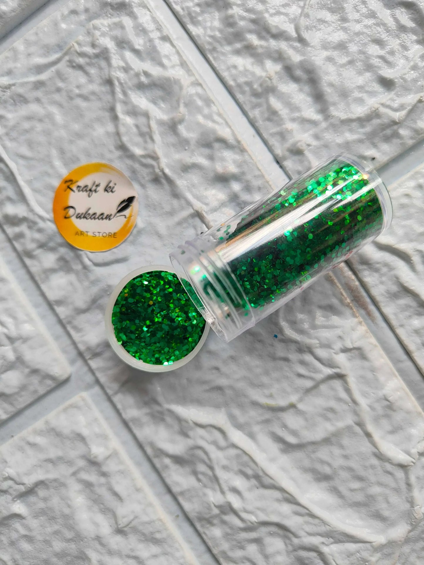 Glitter chunks in clear tube with green glitter sparkle pieces.