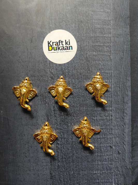 Pack of 10 golden Ganpati face charms, 3.5cm—five shown on dark fabric