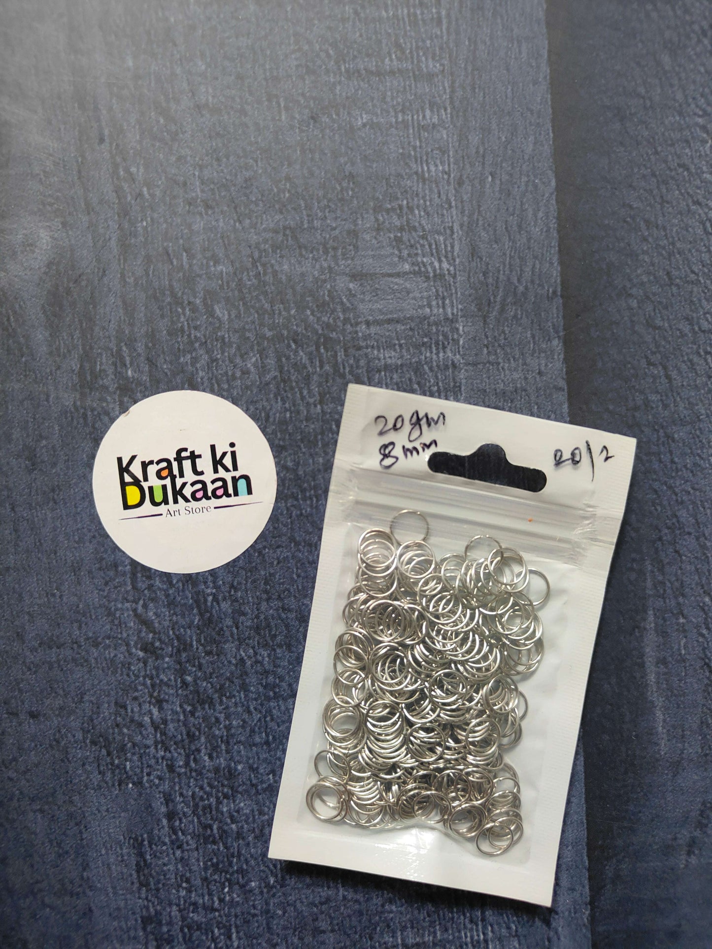 Silver jump rings on card backing, clear pack holding stacked round rings.