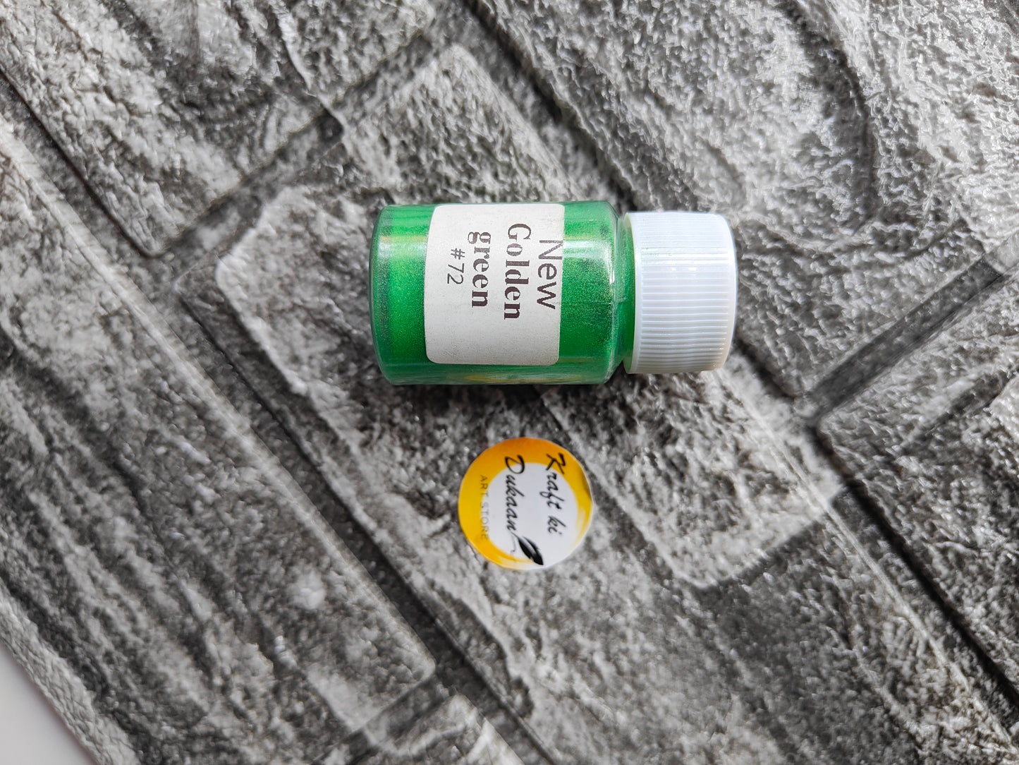 Green mica powder for resin art in a small container for vibrant coloring and creative projects