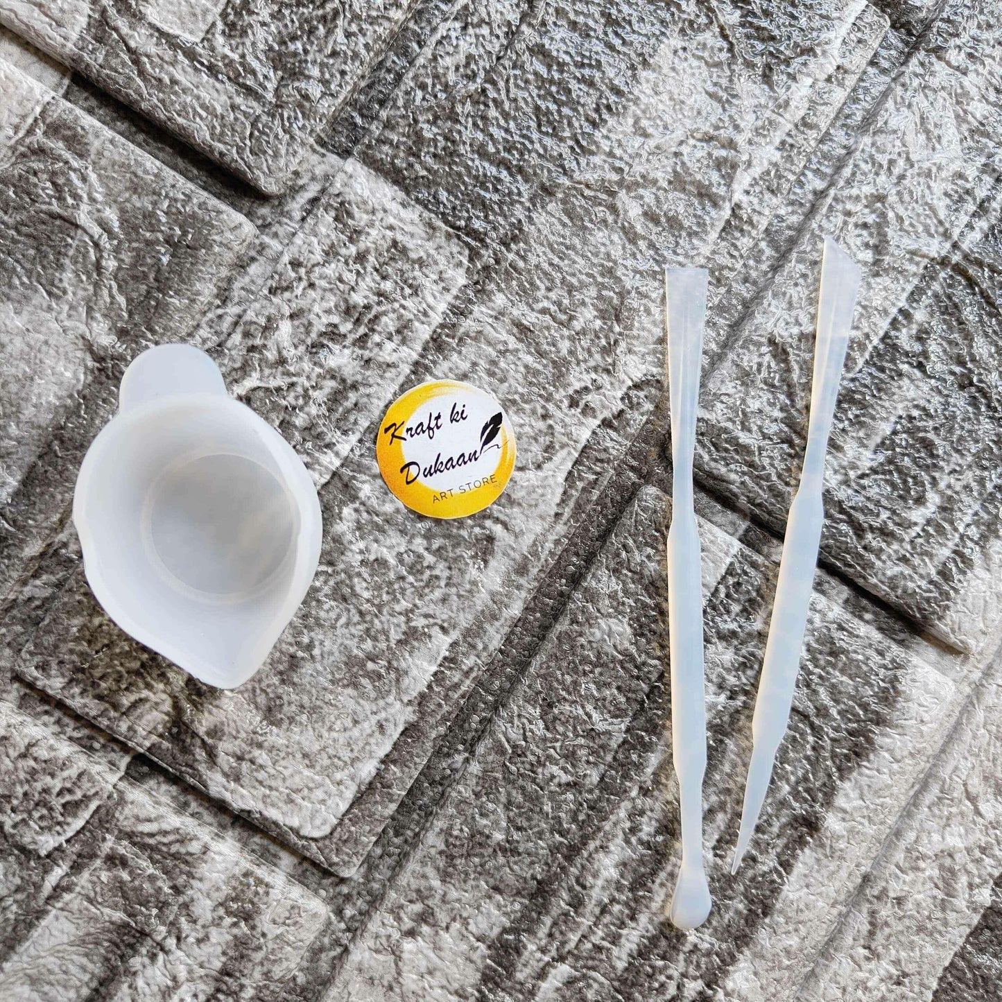 Small white mixing cup with two plastic stir sticks