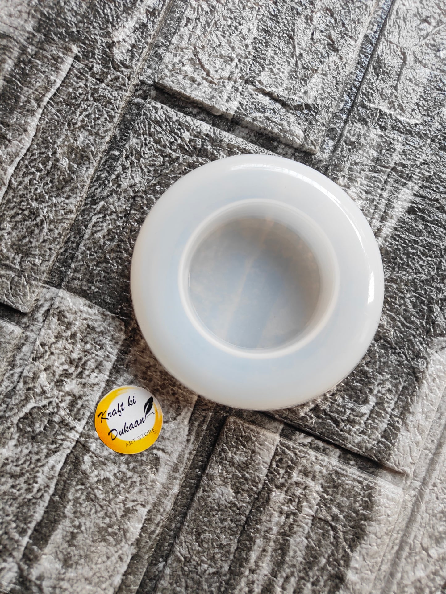 White round t-light holder mould by Kraft ki Dukaan on textured surface for candle making
