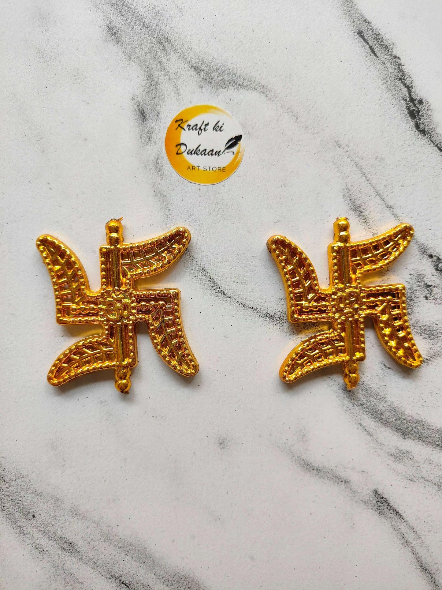 Pair of swastik design beads, gold tone with textured detailing