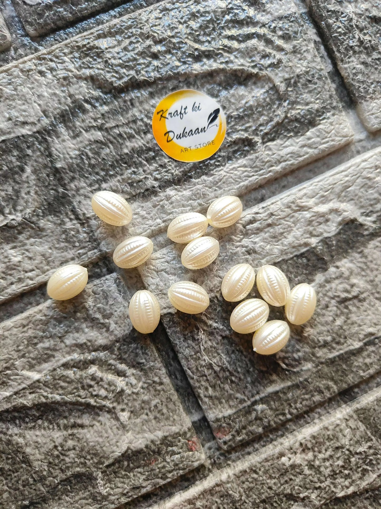White nariyal beads scattered: small oval cream-white coconut-shell beads