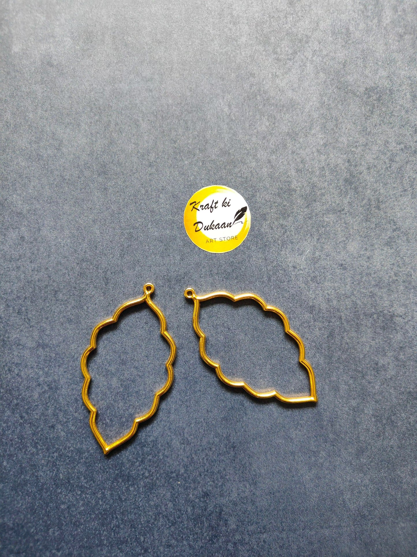 Gold-tone leaf bezel pendant frames, scalloped quatrefoil outline with loop