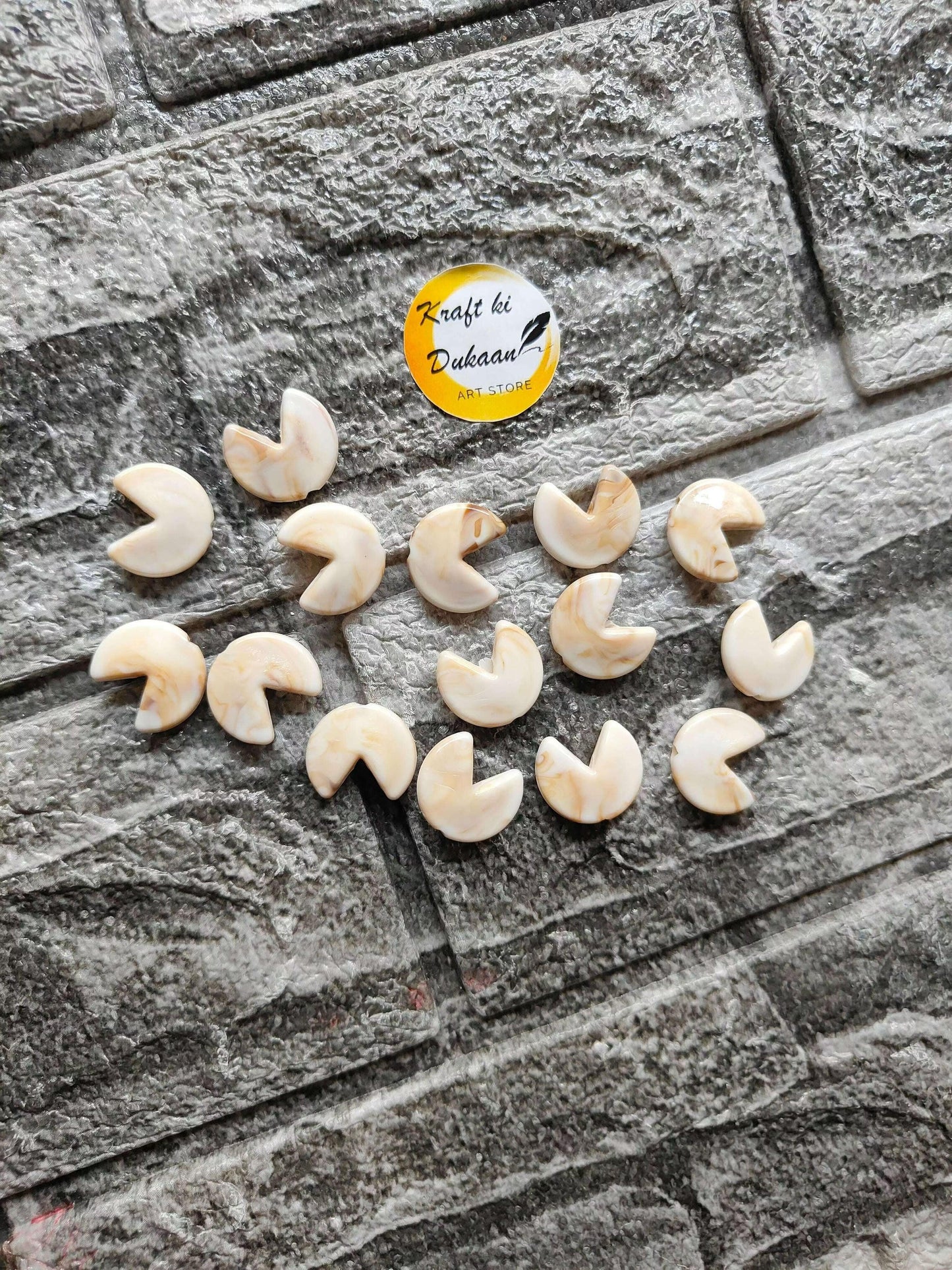 Marble beads fortune cookie charms, pale white with marbled swirl pattern, laid out