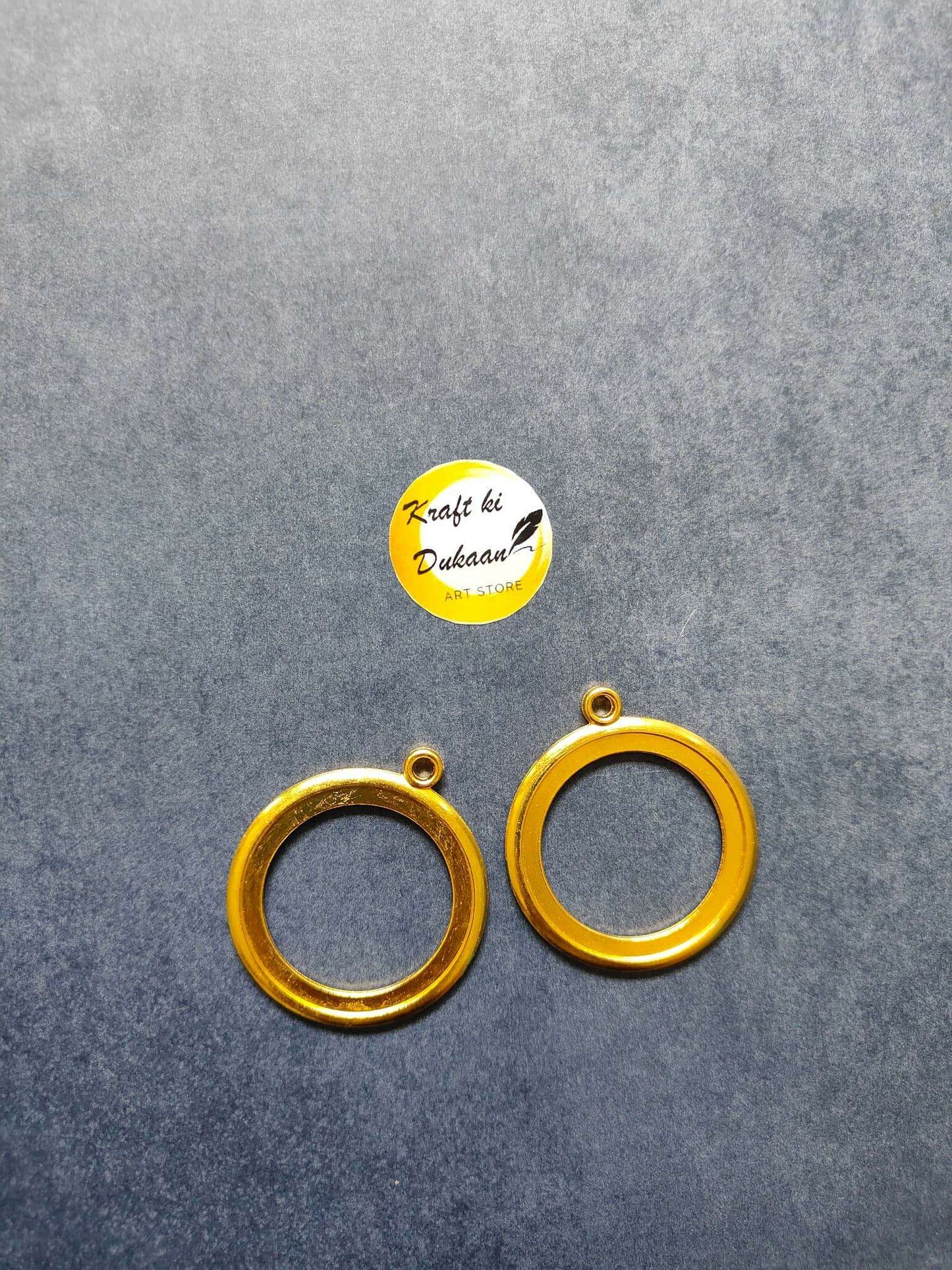 Round thick bezel set in gold-tone: 2 circular rings with top loops