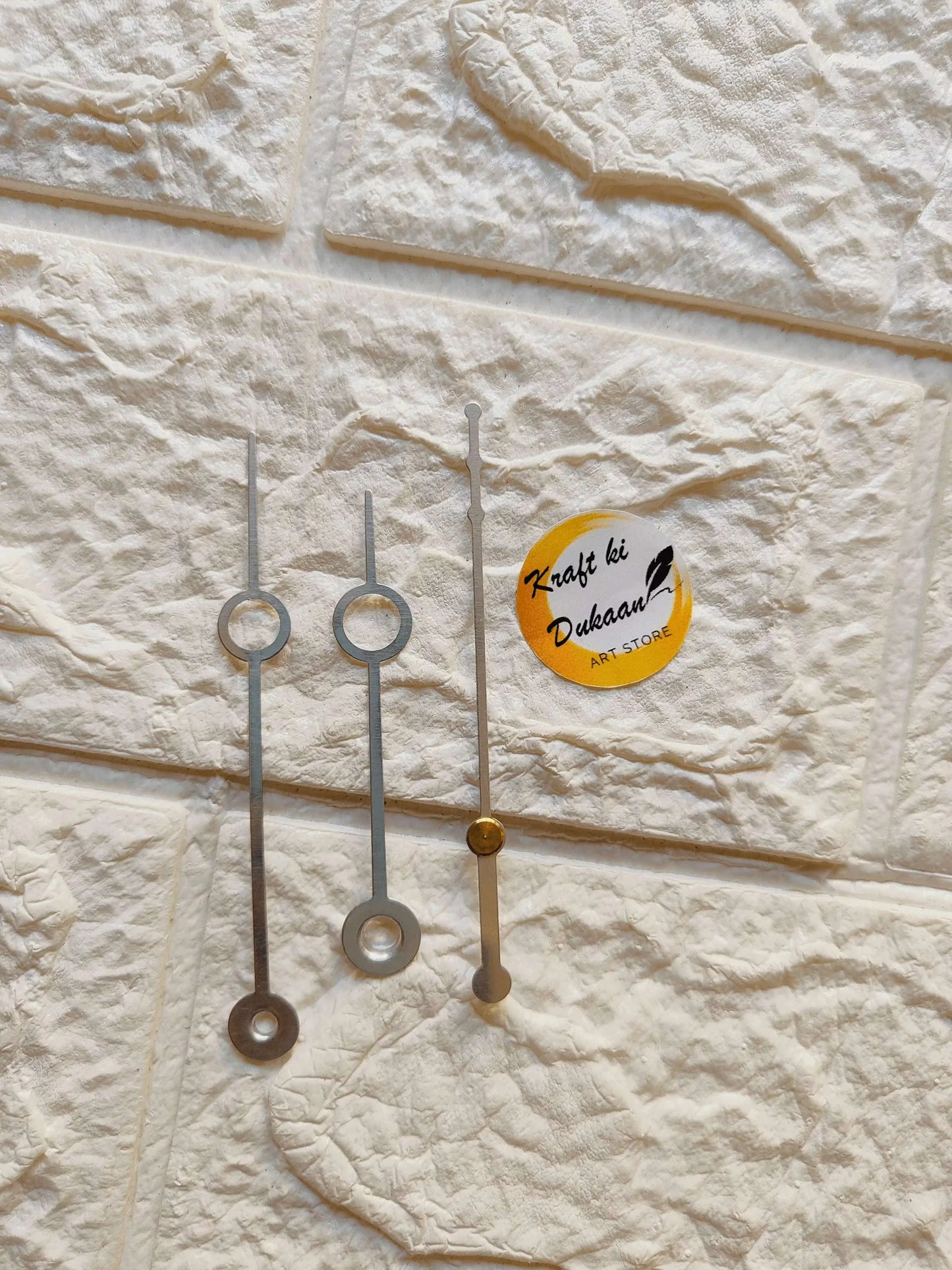 Silver metal clock hands with round discs and one gold center hand
