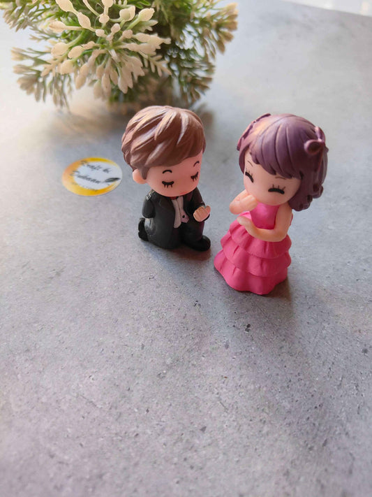 Miniature Model A9: kneeling boy in dark outfit and girl in bright pink layered dress