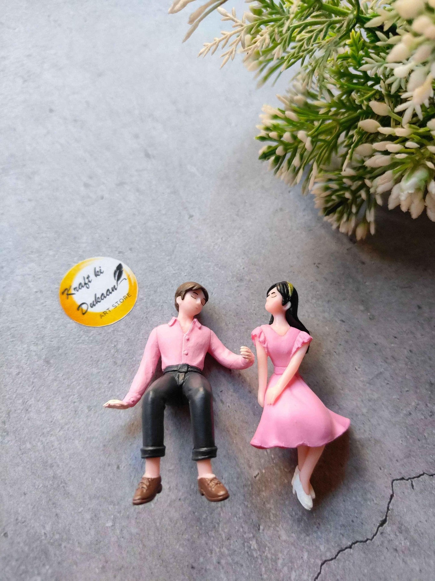 Miniature Model A3: two seated figurines, pink outfits, black pants, brown shoes