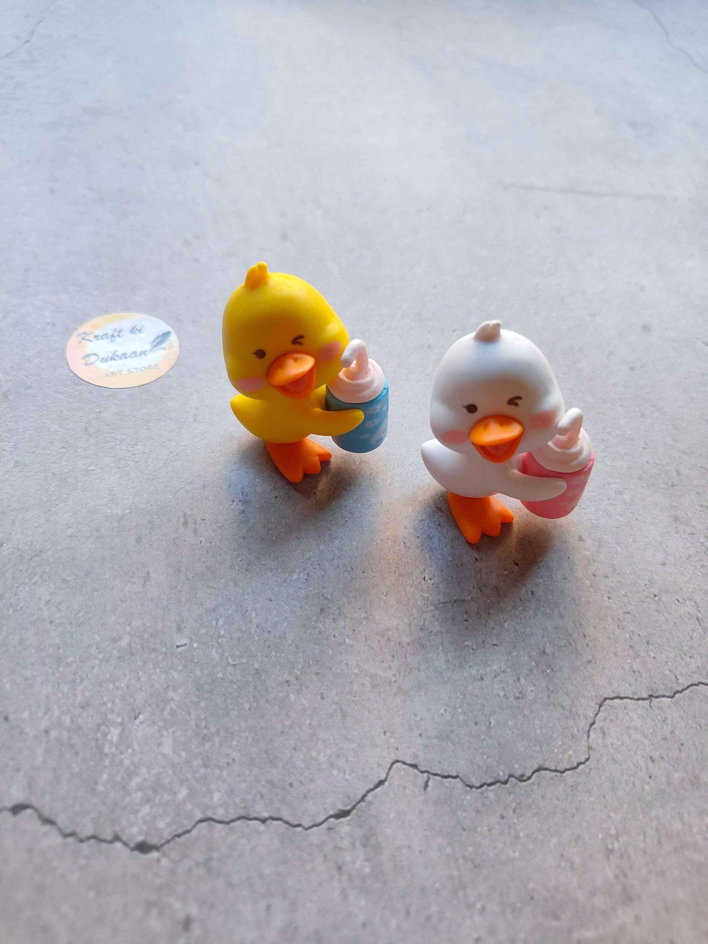 Miniature Model A24: yellow & white chick figurines, one holds a small blue piece.