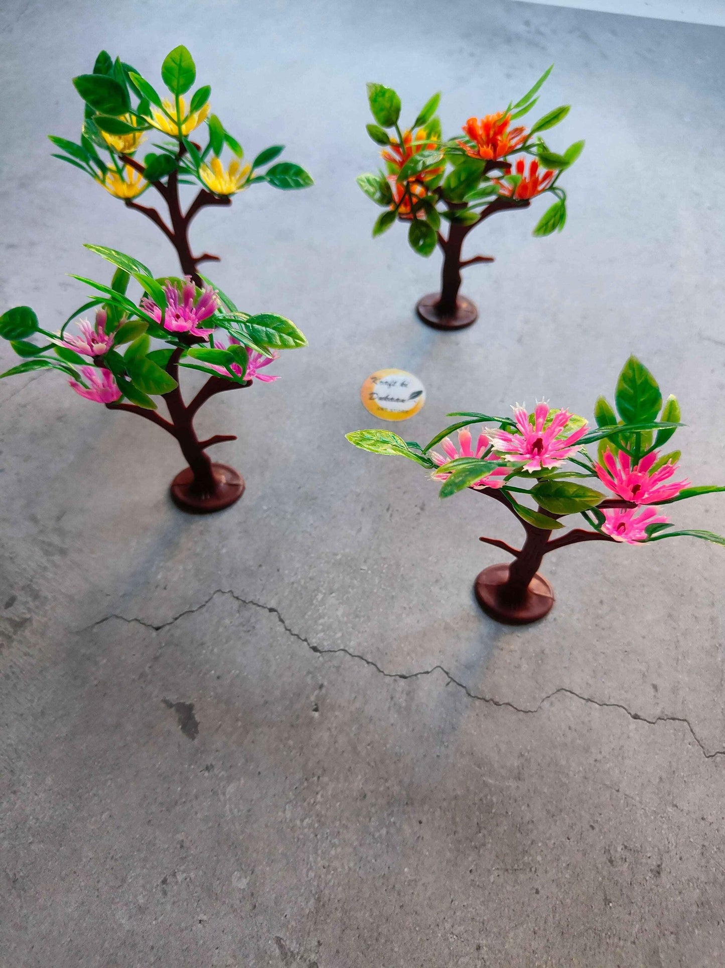 Miniature model A28: three flowering trees with green leaves, pink and yellow blooms