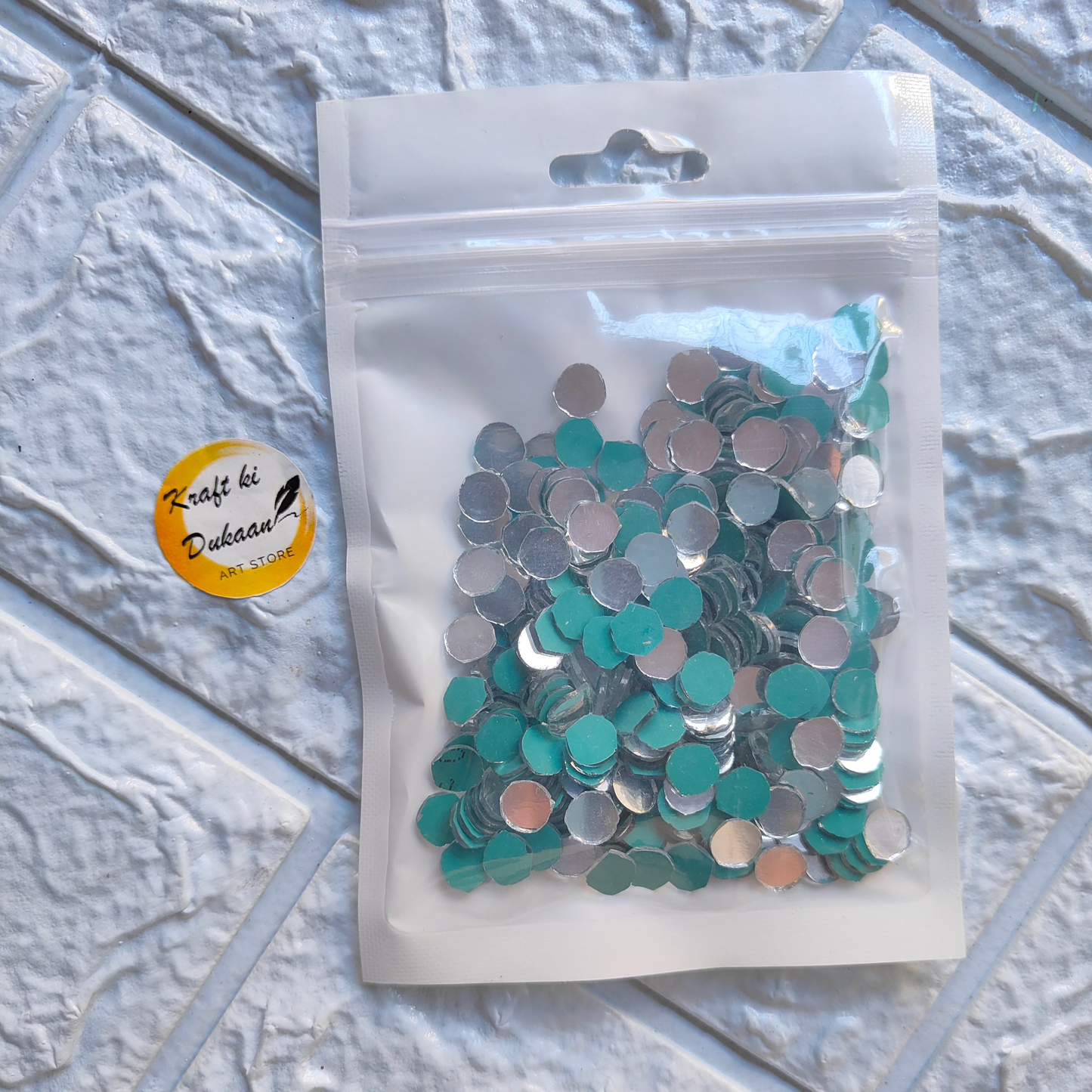 Mirror mosaic craft supplies in assorted colors packed in a clear plastic bag for creative projects