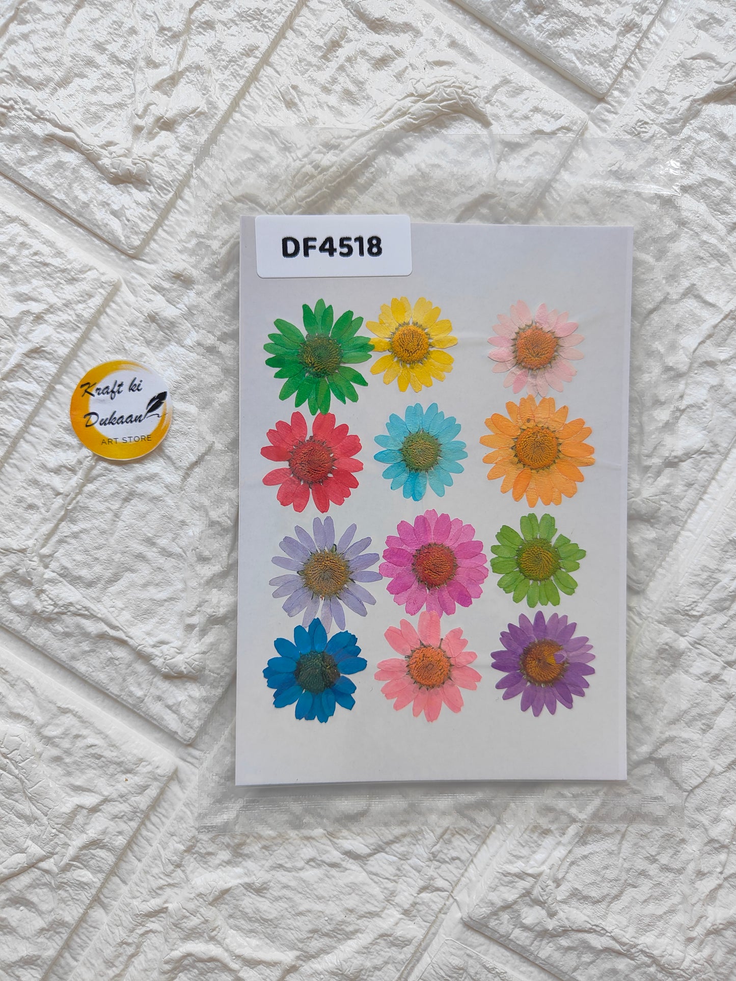 Craft kit featuring multi-color pressed flowers arranged on a textured background for DIY projects