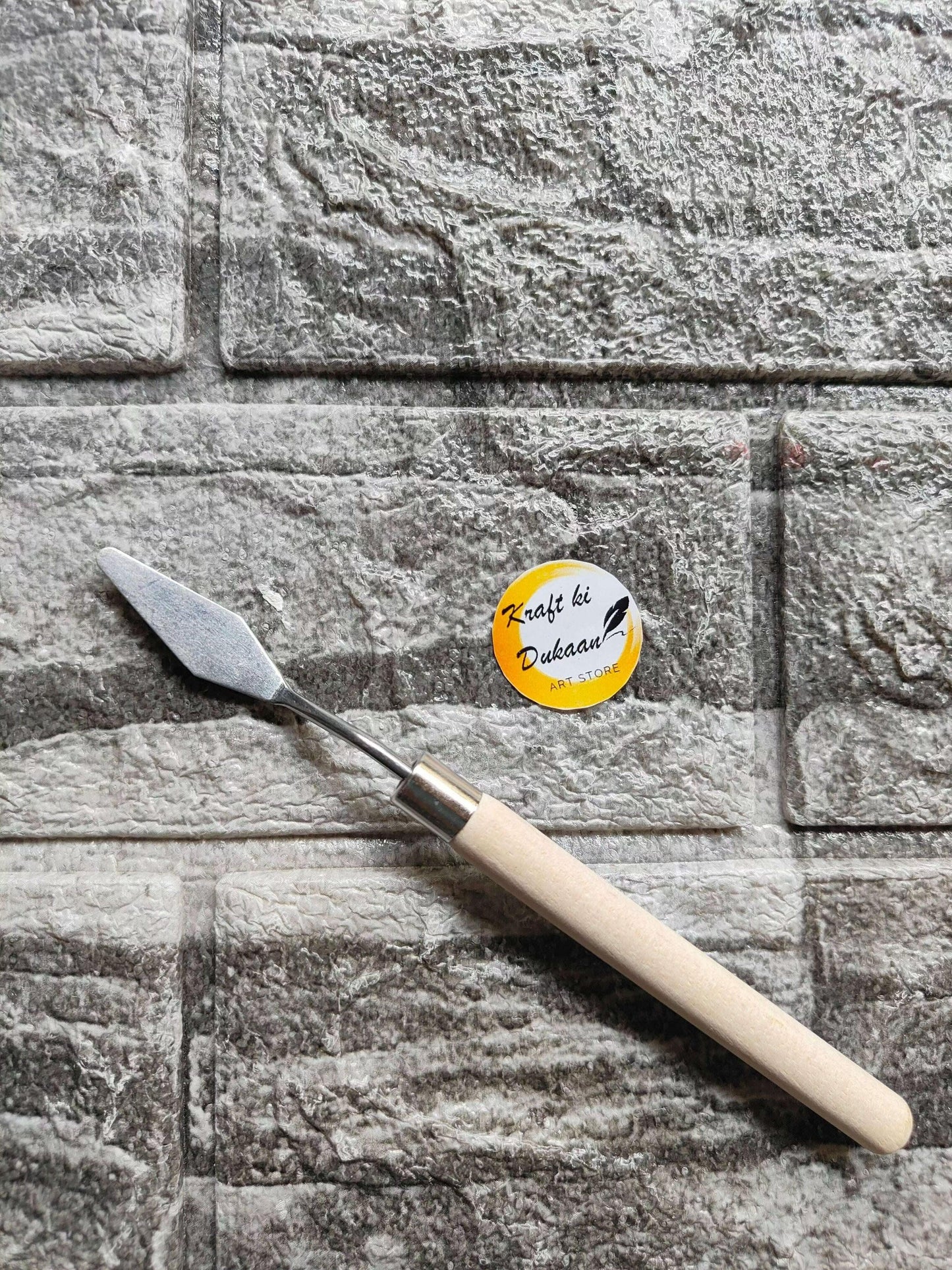 Painting knife with pale wooden handle and angled metal blade
