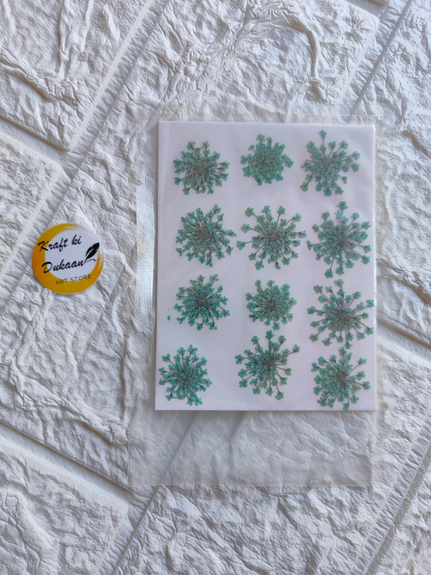 Pressed flower art supplies featuring various green floral designs on a sheet from Kraft ki Dukaan