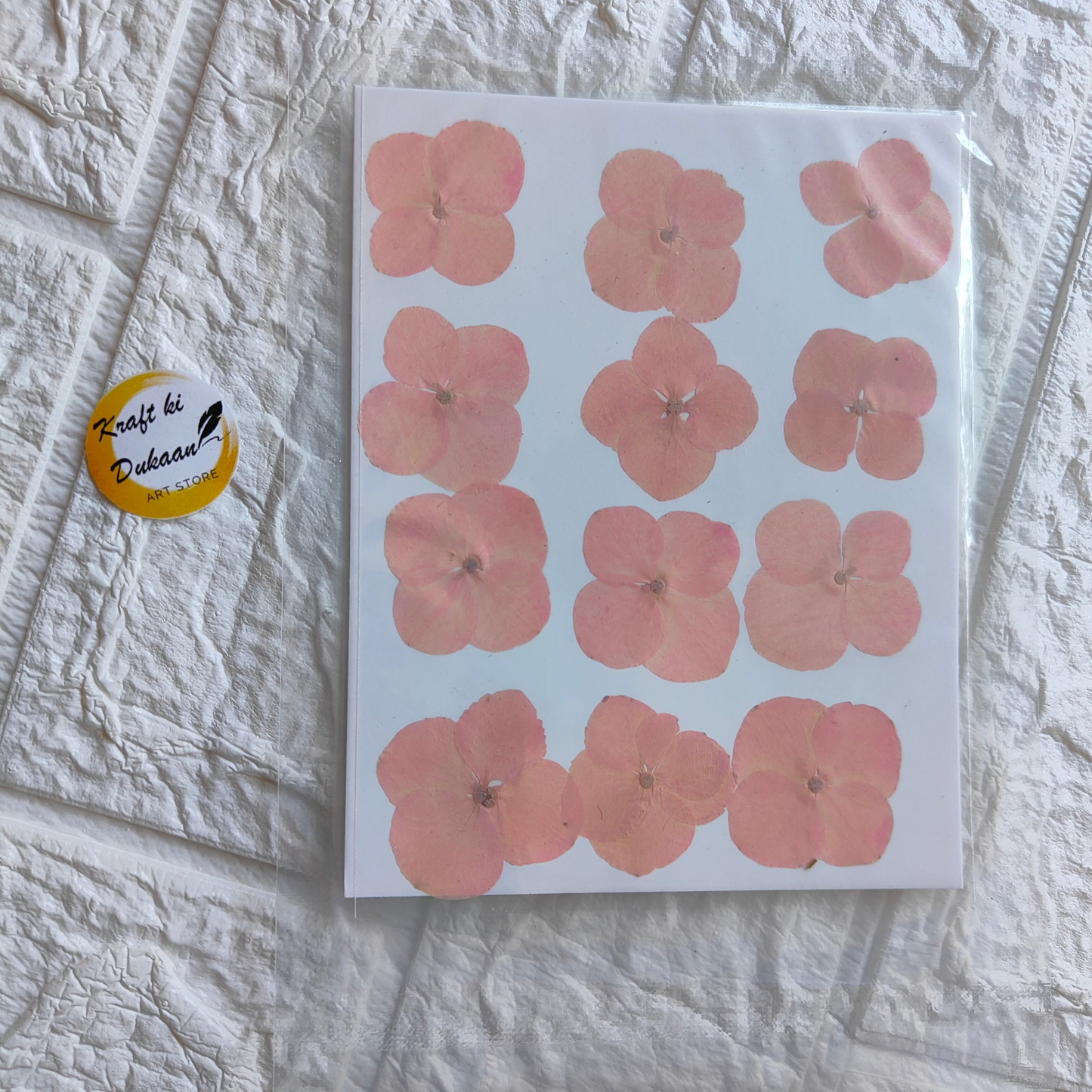 Pressed flower sheet for crafts featuring pink flowers in various shapes and sizes, suitable for DIY projects