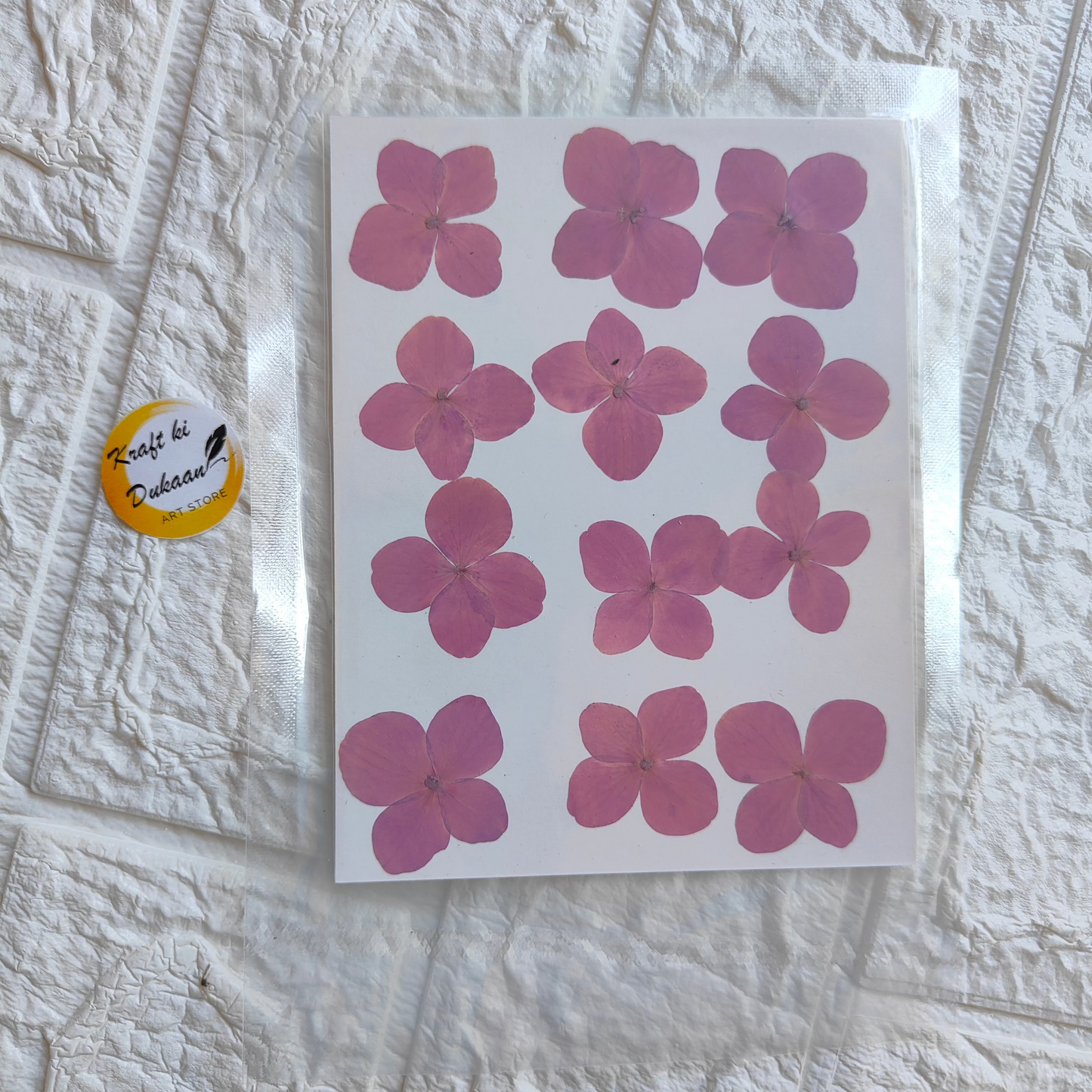 Pressed flower sheet for crafts featuring pink flowers arranged in a decorative pattern