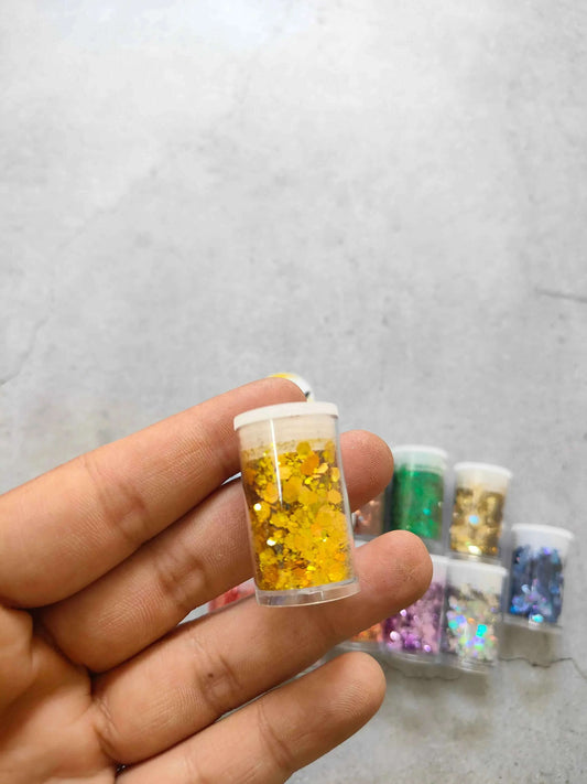 Yellow resin glitter hexagon flakes, medium size, in a small clear bottle
