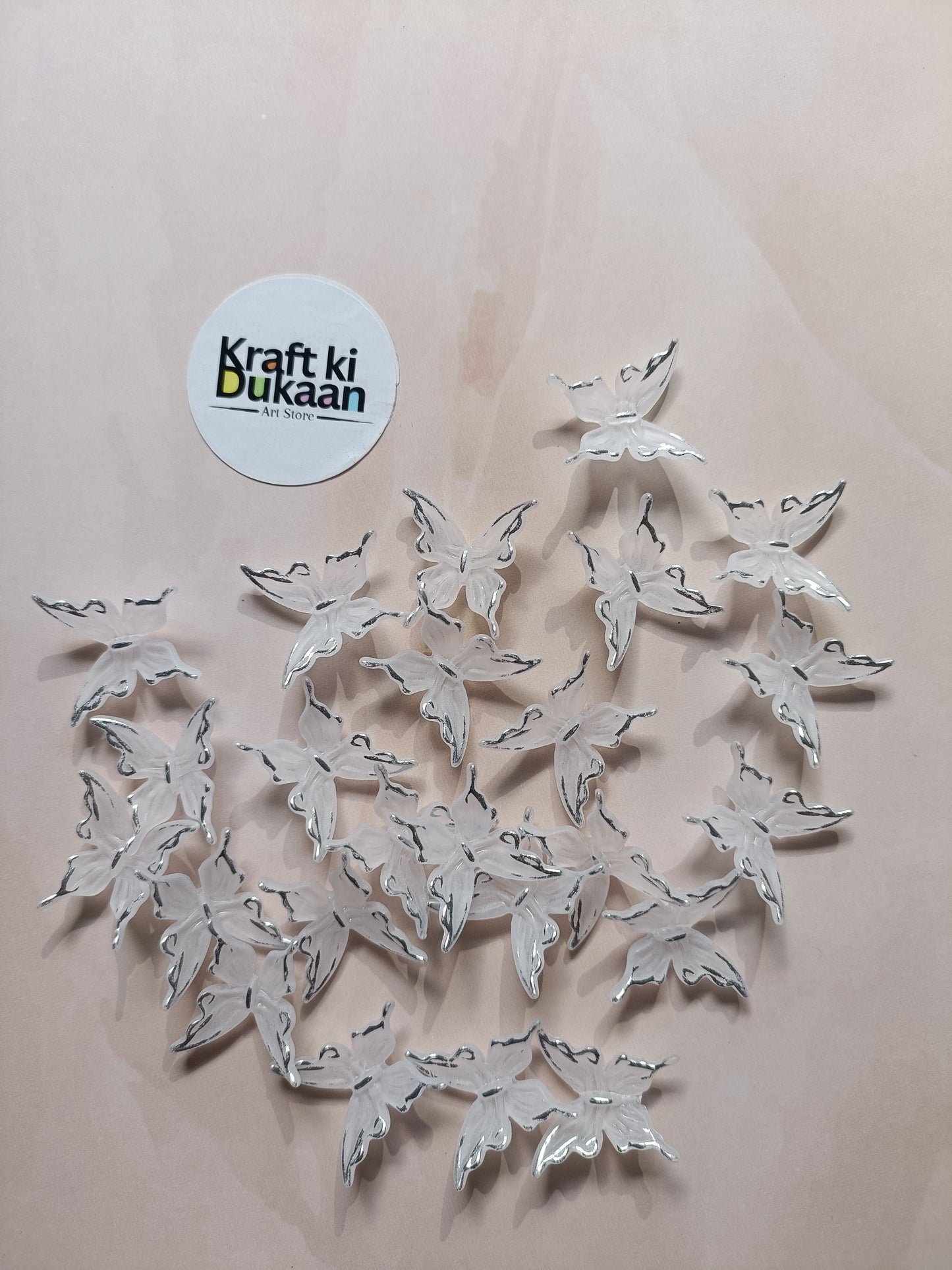 Silver butterfly beads scattered on background with metal loops