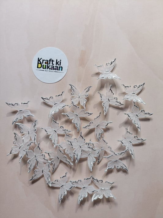 Silver butterfly beads scattered on background with metal loops