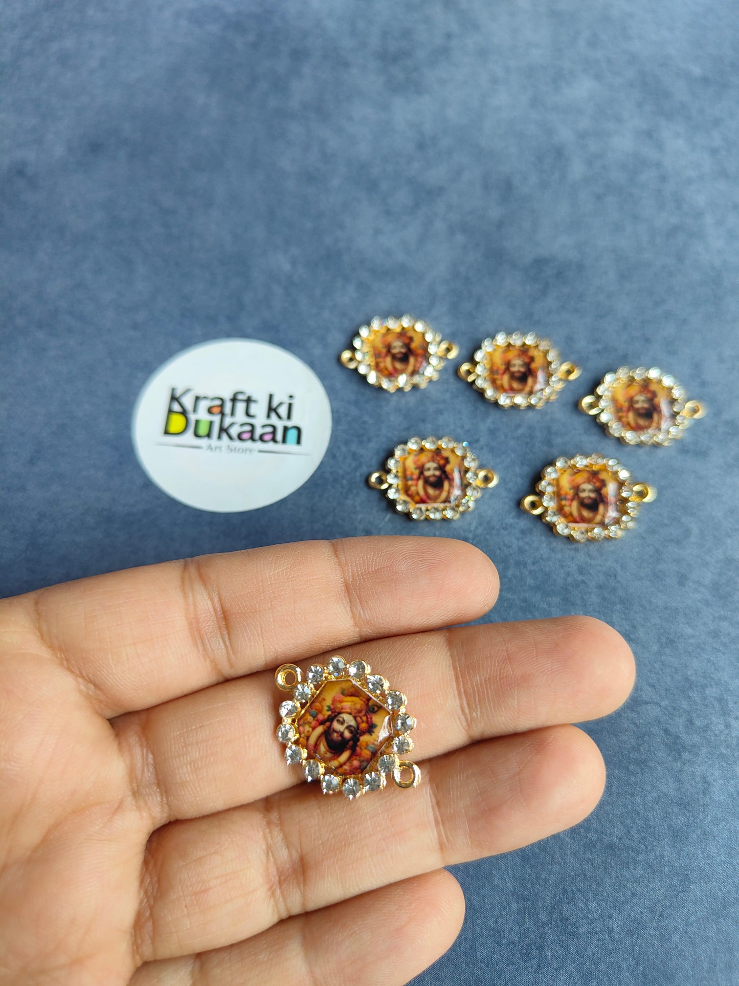 Rakhi bracelet pendant, gold-tone circular medallion with deity center and beaded border