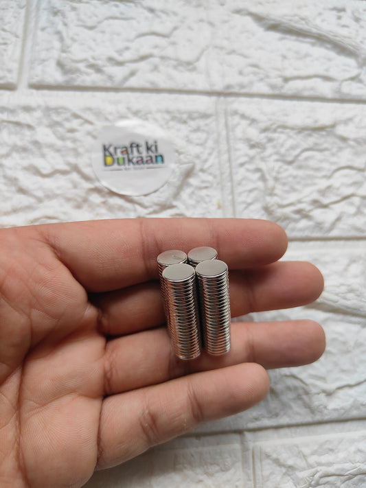 Round steel magnet pins, 10 x 1.5 mm, silver discs held in hand