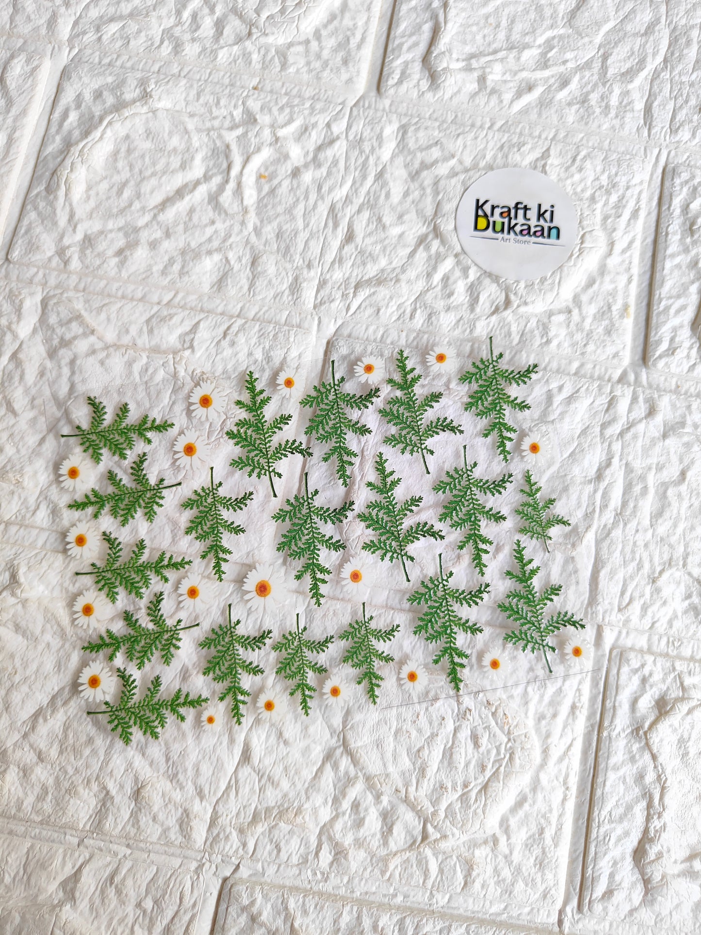 Peel-off UV DTF sticker sheet with green pine sprigs and white daisy flowers
