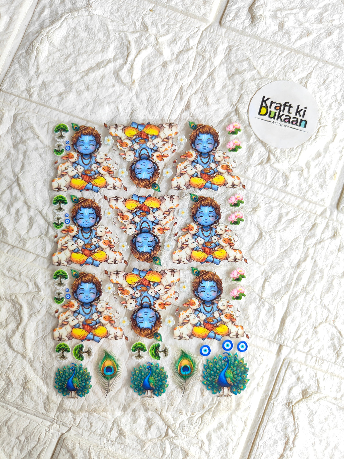 Peel-off sticker sheet with blue baby deity figures, peacocks, and floral accents