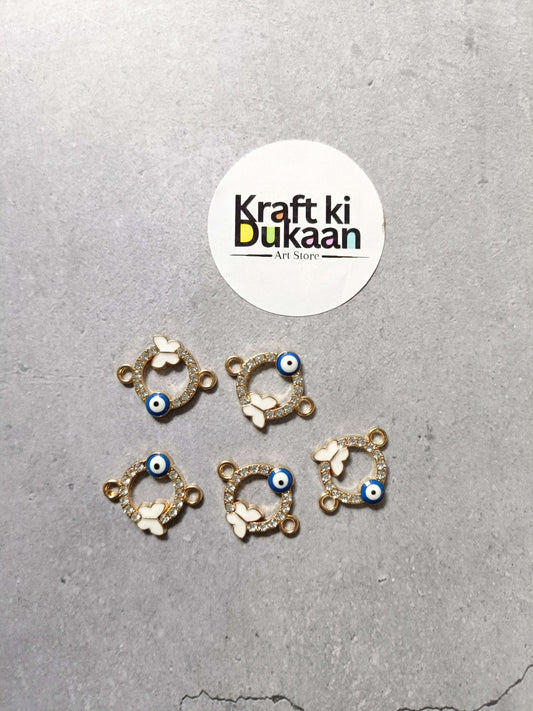 Five gold-tone evil eye bracelet charms, circular white butterfly details with blue bead