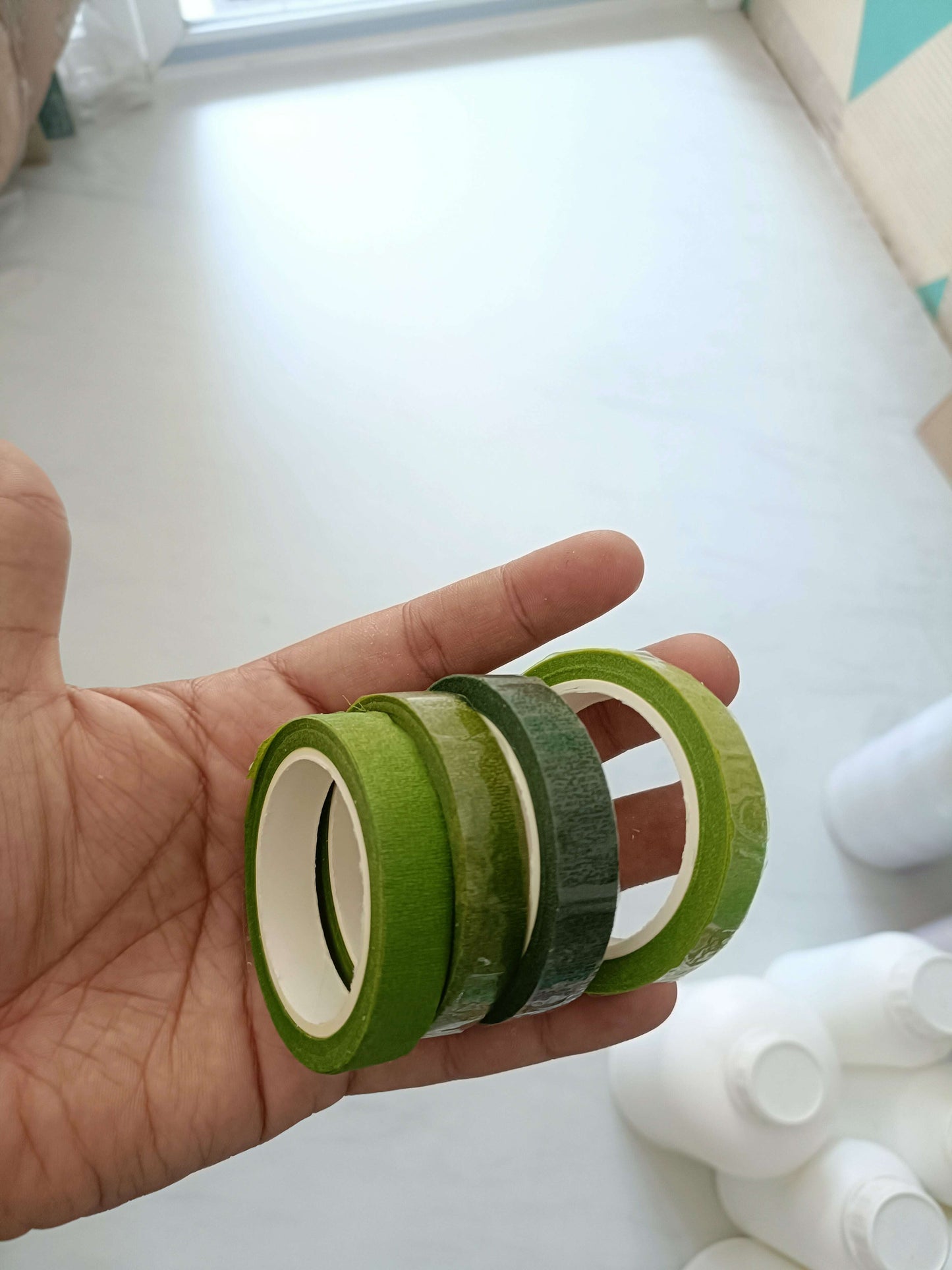 Floral Tape in green, held in a hand showing two tape rolls